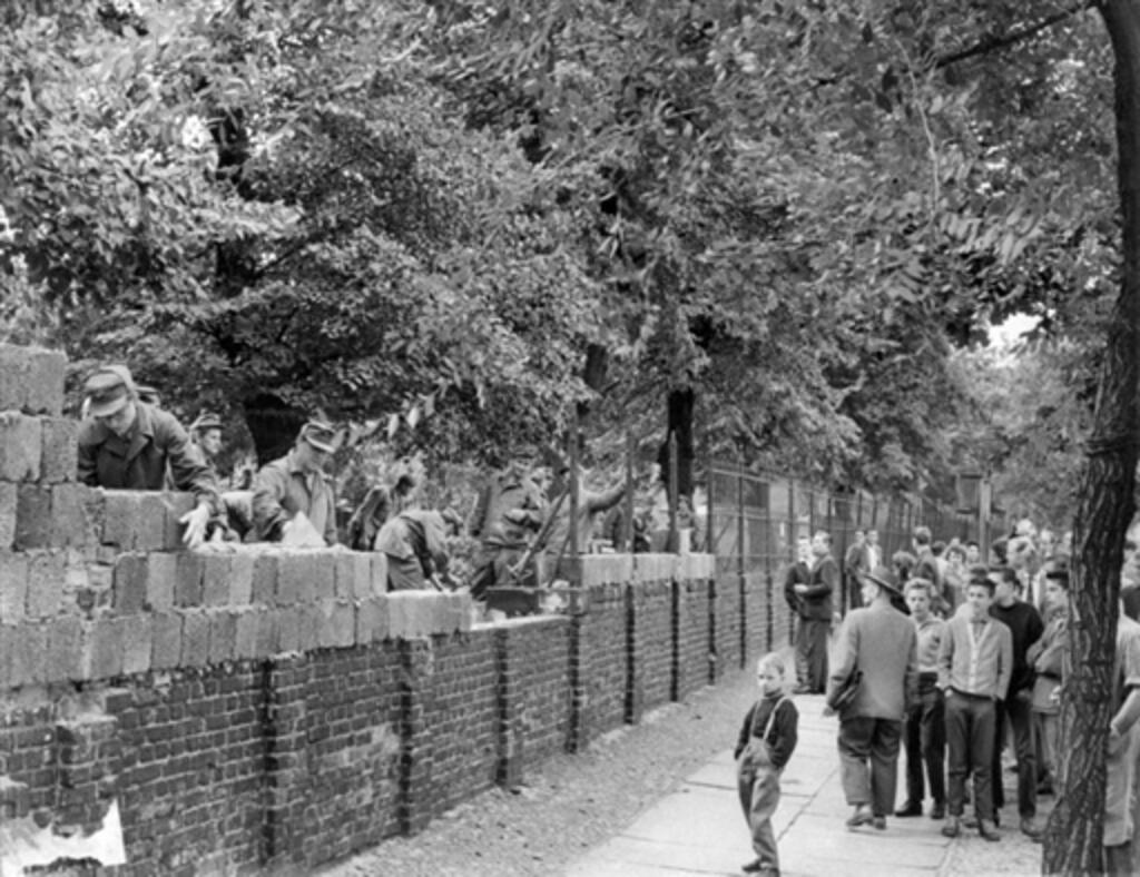 East German workers build up a section of the Berlin wall, on 15 August 1961.