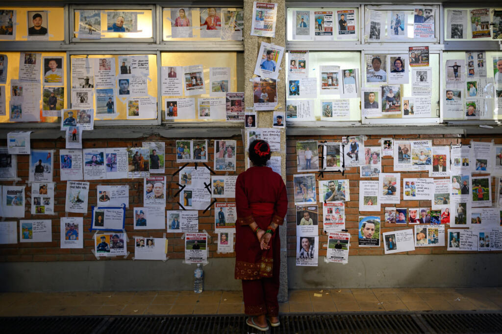 A woman looks at photographs of missing persons in the aftermath of flash floods, at the Tribhuvan University Teaching hospital in Kathmandu