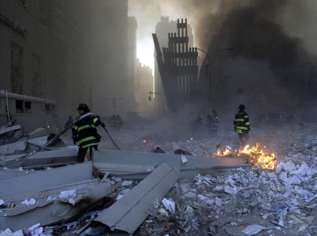 Firemen work in the remains of the World Trade Center, 11 September 2001.