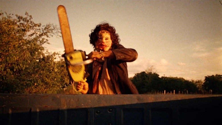 Leatherface (Gunnar Hansen) chases a truck with a chainsaw in The Texas Chain Saw Massacre