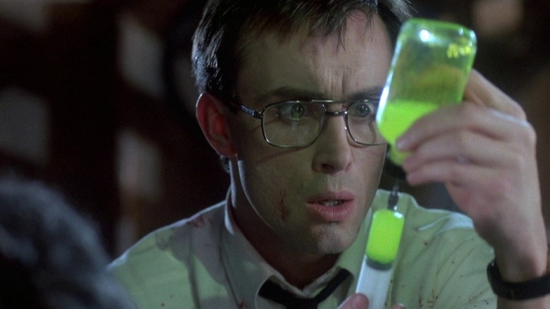 Jeffrey Combs as Herbert West in Re-Animator, filing up a syringe with a dose of his glowing green goo.