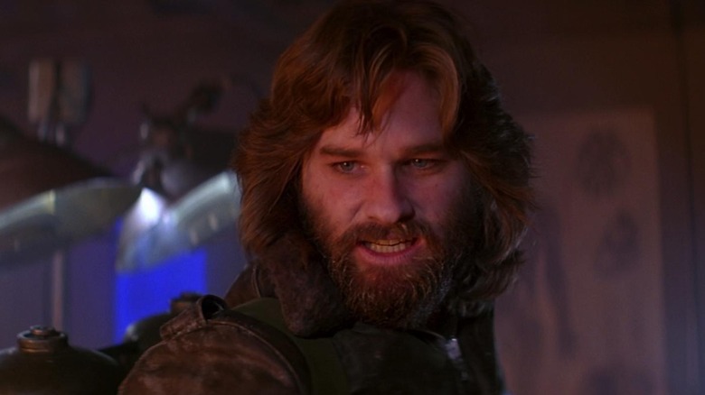 Kurt Russell as R. J. MacReady in The Thing, bearing his teeth while looking at something out of frame.