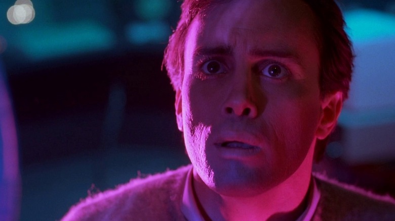 Jeffrey Combs as Dr. Crawford Tillinghast in From Beyond, looking on in horror as pink and fuchsia lighting bathes his face.