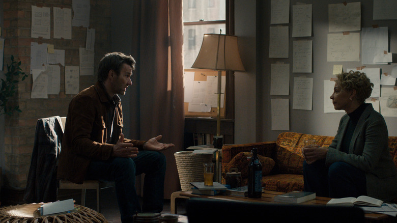 Joel Edgerton as Jason Dessen sitting in a room covered in research notes opposite Amanda Brugel as Blair Caplan in Dark Matter
