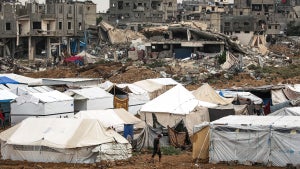 A man walks past shelter tents erected near collapsed buildings in the Bureij camp for Palestinian refugees in the central Gaza Strip on October 1, 2024 amid the ongoing war in the Palestinian territory between Israel and Hamas