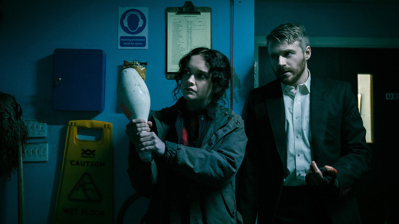 Olivia Cooke's Sidonie Baker holds a bowling pin as she stands next to Jack Lowden's River Cartwright in Slow Horses