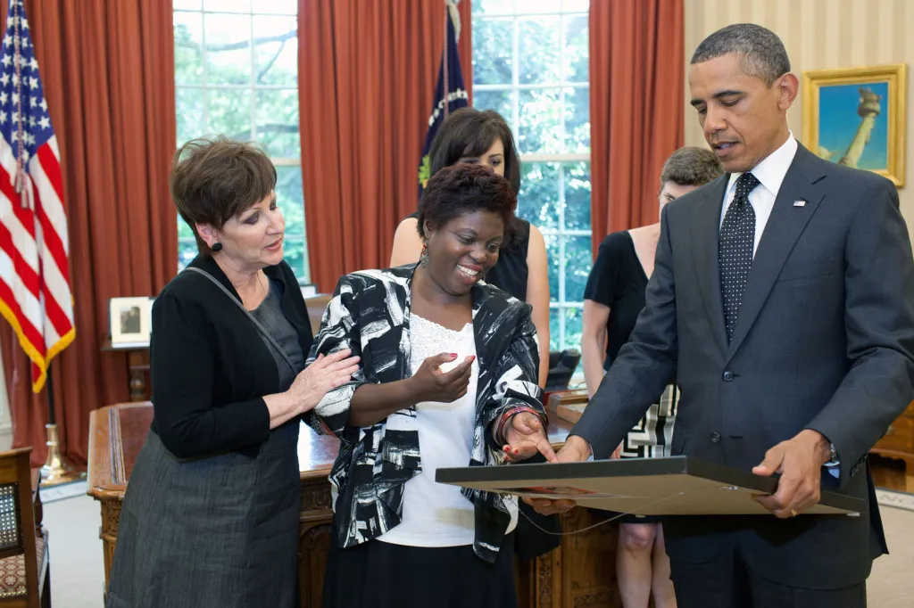 Obama and several other people look at a painting by Lois Curtis.