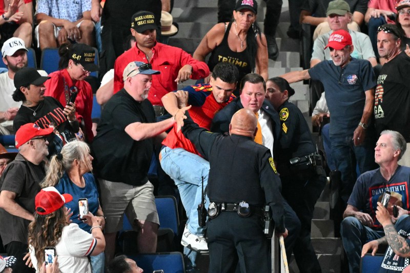 A protester is restrained by Sheriff deputies and supporters of US President Donald Trump as the president speaks during a campaign rally at the Freeman Coliseum in San Antonio, Texas, on October 7, 2026. Republican Senate candidate Ken Paxton is in a close race with Democratic candidate James Talarico for one of Texas' US Senate seats. (Photo by Mandel NGAN / AFP via Getty Images)